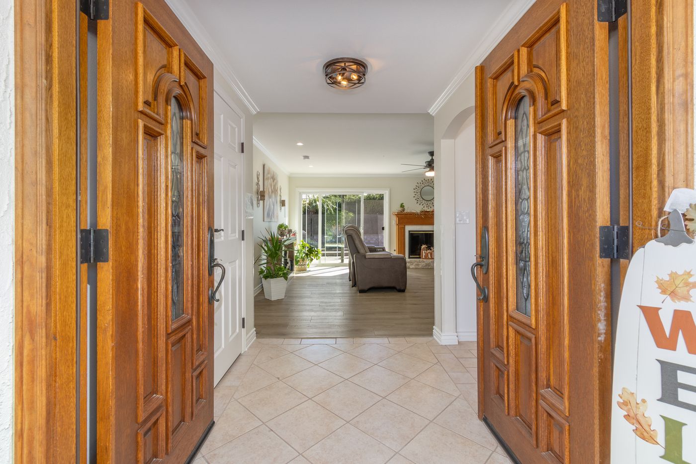 The double front doors open onto the living room, with the backyard beyond