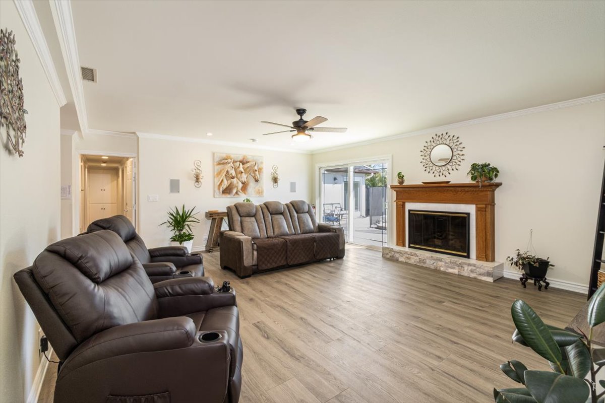 The living room: power recliners and a sofa by the fireplace, with sliding doors to the backyard